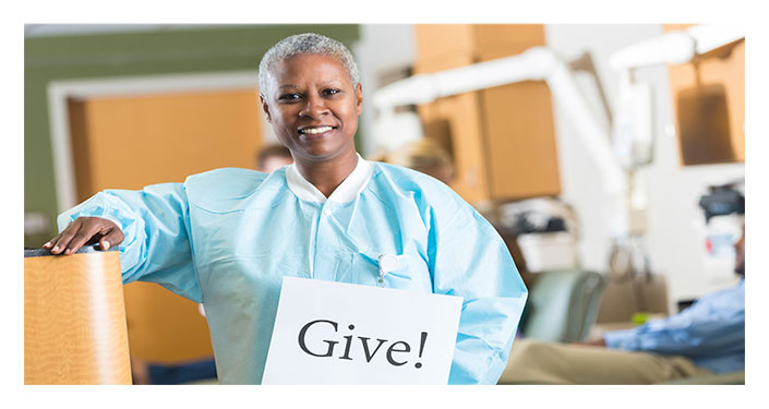 Image of a nurse holding a "give" sign
